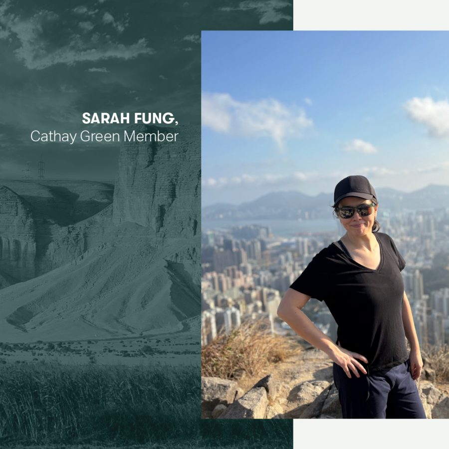 Sarah Fung smiling on a hiking trail in the daytime with a view of buildings in the background.